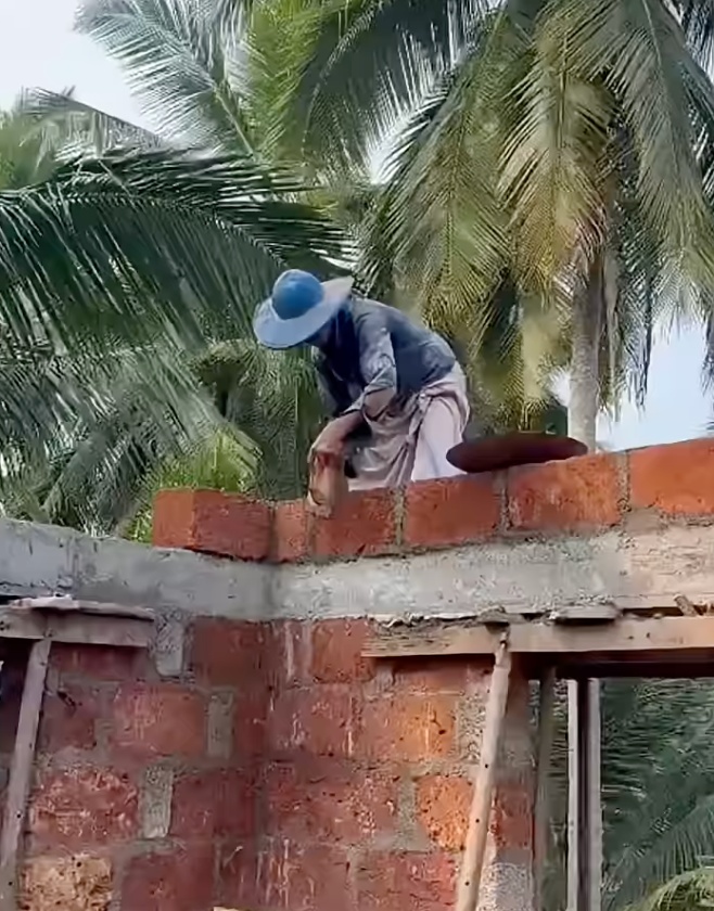 Laterite blocks being laid above an RCC beam in Saligao